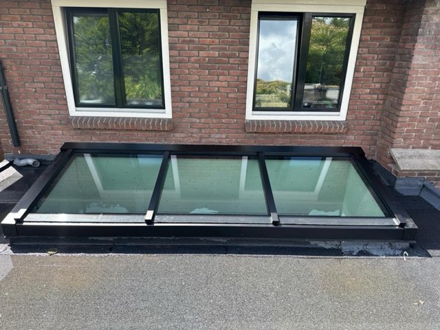 Lessenaardaklichtstraat tegen een bakstenen gevel