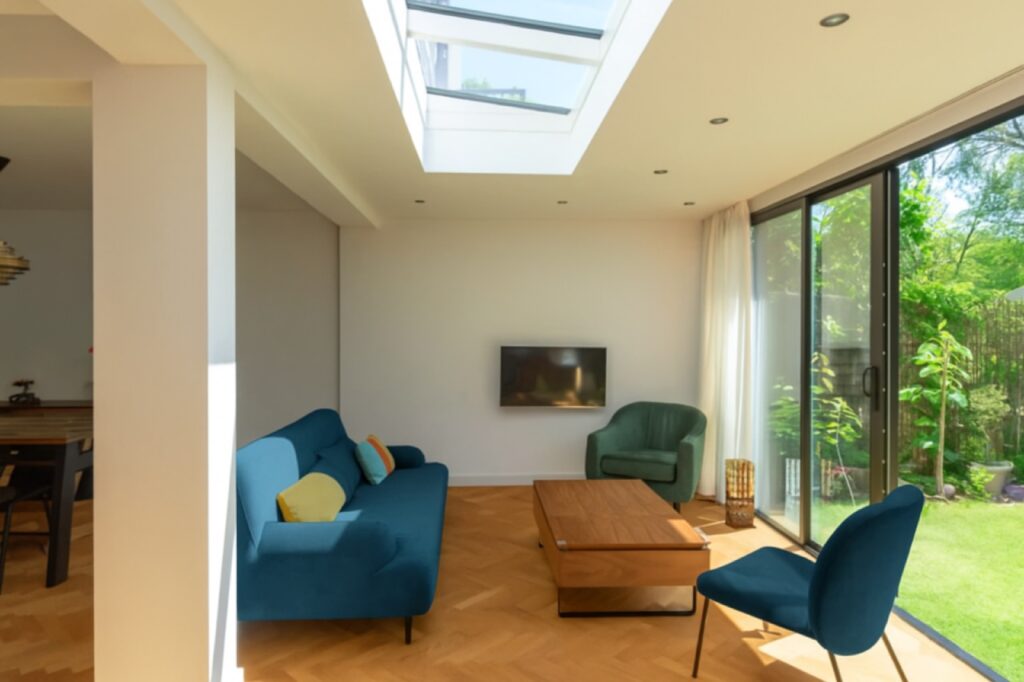Lichte woonkamer in een aanbouw met een lichtstraat in het plafond
